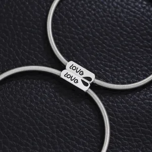 Stainless steel spring couple bracelet detail shot, matching love charm design for lovers.