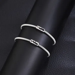 Stainless steel spring couple bracelet detail view, featuring little prince sun and moon design charms.