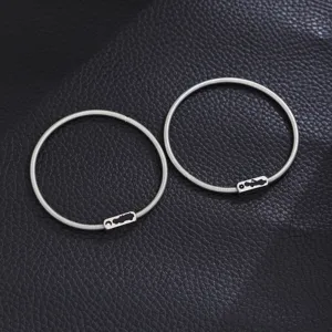 Stainless steel spring couple bracelets detailed shot, minimalist fashion jewelry pair.