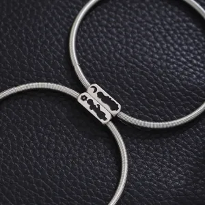 Stainless steel spring couple bracelet detail showing the sun and moon pendant charms.