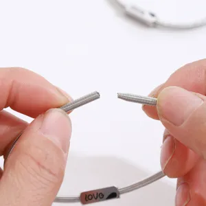 Close-up detail of stainless steel spring bracelet showing flexible opening and engraved plate.