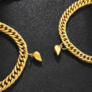 Gold stainless steel Cuban link couple bracelets with magnetic heart pendants for lovers.