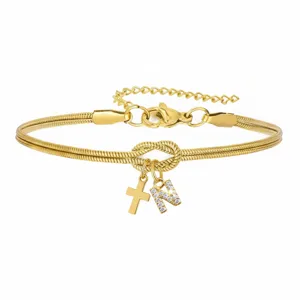 Vista dettagliata del bracciale in catena di serpente dorata con nodo e lettera.