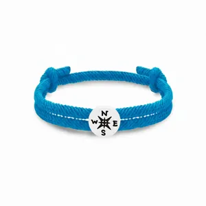 Blaues geflochtenes Seilarmband Detail mit weißem runden Kompass Anhänger für den Alltag.