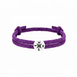 Lila geflochtenes Seil Kompass Armband Detail mit filigranem Gewebe und Metall Charm.