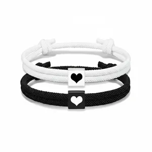 Pulsera de cuerda trenzada con dije de corazón para pareja ajustable negro y blanco detalle