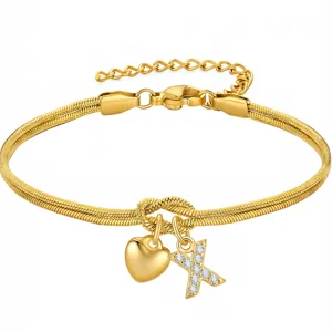 Dettaglio del bracciale in catena a serpente dorata con nodo d'amore e ciondolo con lettera.