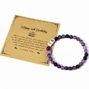 Detalle en primer plano de pulsera de cuentas de amatista natural con número 16 y tarjeta.