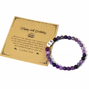 Detalle de pulsera de cuentas de amatista natural con tarjeta de felicitacion de cumpleanos.
