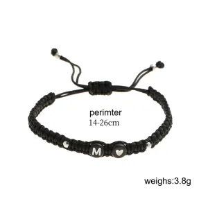Dettaglio del bracciale intrecciato nero regolabile con l'iniziale M e il cuore