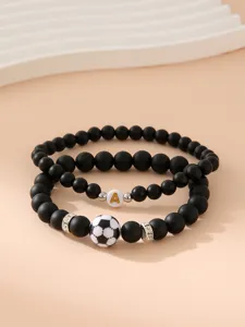 Dettaglio di set di bracciali in perline nere opache con calcio e ciondolo lettera A