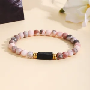 Detailed shot of fashion pink zebra stone and tourmaline beaded bracelet with gold spacers.