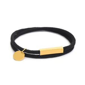 Bracciale minimalista in corda di Milano nera con barra magnetica dorata e medaglietta.