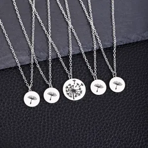 Gros plan sur des pendentifs ronds en acier inoxydable argenté aux motifs de pissenlit.