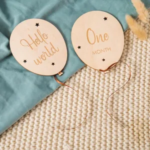 Wooden baby milestone balloon card, detailed shot of engraved month props for newborn photo.