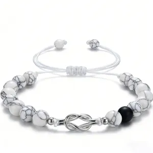 Detail view of white howlite beaded couple bracelet with silver knot and black matte stone.
