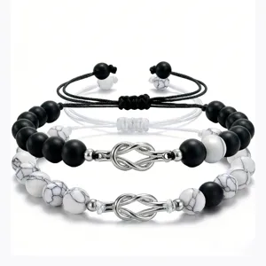 Natural stone couple bracelets featuring black matte and white turquoise beads with silver knot.