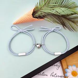 Detailansicht von Paaren magnetischen Herz passenden Armbändern mit hellem blauen Seil.