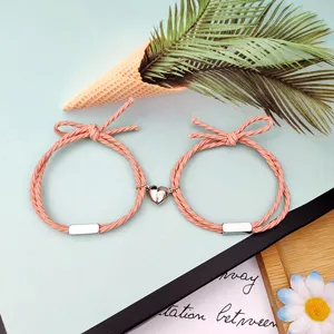 Detaillierte Nahaufnahme von passenden rosafarbenen Seil-Pärchenarmbändern mit Herz.