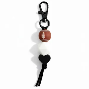 Close-up detail of sports style rugby bead keychain with black tassel and metal clasp.