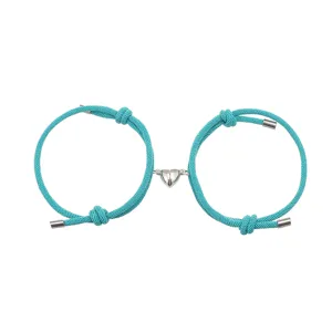 Gedetailleerd overzicht van turquoise gevlochten touw armband met magnetisch hart.