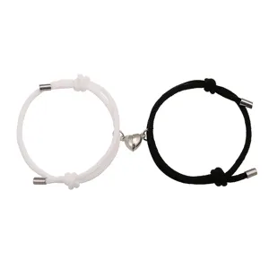 Gedetailleerd overzicht van zwart-witte gevlochten koppel magnetische hart armbanden.