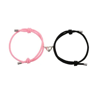 Set van magnetische koppelarmbanden van gevlochten touw met bijpassende hartbedel voor geliefden.