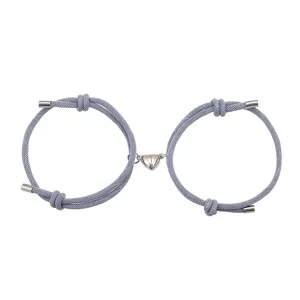 Gedetailleerd overzicht van grijze gevlochten koppel magnetische armbanden, minimalistisch.