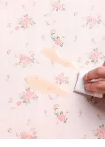 Close-up detail shot of waterproof drawer liner paper with delicate pink rose pattern wiping clean.