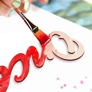 Close-up detail shot of wooden script wall decor letter painted in vibrant red color.