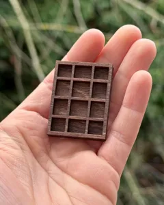 Gros plan détaillé sur l'étagère miniature en bois à 12 compartiments pour minéraux.