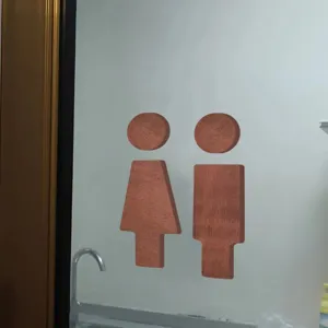 Wooden toilet sign detail shot showing the creative male and female restroom wall decor installed.
