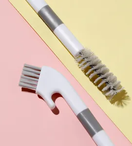 Close-up view of Japanese style dual-head cleaning brush with hook and stiff bristles.