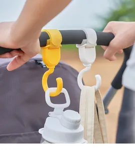 Close-up detail of 360-degree rotating stroller hooks holding bottles and bags securely.