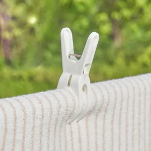 Pince à linge en plastique robuste image principale montre clip blanc sur tissu rayé.