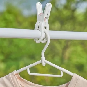 Pince à linge en plastique et cintre coupe-vent pour séchage extérieur, design robuste.