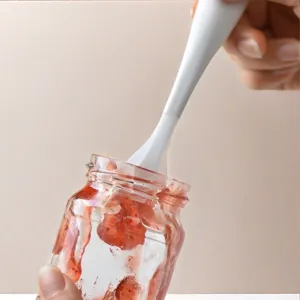 Mini silicone jam spatula spoon for kitchen use, cute standing design in white color.