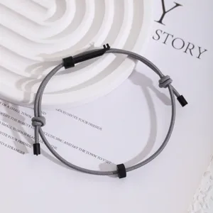 Graues Survival Seilarmband mit schwarzem Zahnradwerkzeug und verstellbarem Knoten.