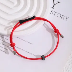 Detailansicht des roten elastischen Überlebensseilarmbands mit Zahnradperle und Miniteilen.