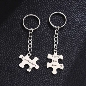 Stainless steel couple puzzle keychain detail shot, engraved love messages, matching key rings.