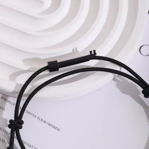 Detailaufnahme des minimalistischen schwarzen geflochtenen verstellbaren Armbands mit Werkzeug.