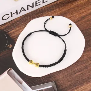 Primo piano dettagliato del bracciale in corda intrecciata nera con ciondolo a manubrio.