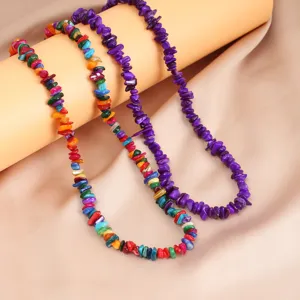 Primo piano dettagliato di collane di perle in pietra naturale colorate e viola da donna.