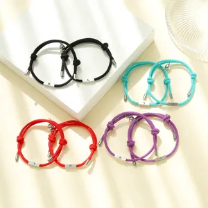 Magnetic couple matching braided bracelets with sun and moon charms in vibrant colors.