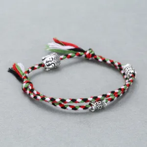 Close-up of handmade woven rope bracelet with Buddha head alloy beads and colorful threads.