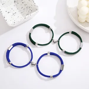 Gedetailleerd overzicht van magnetische koppelarmbanden met gevlochten touwen en hartjes.