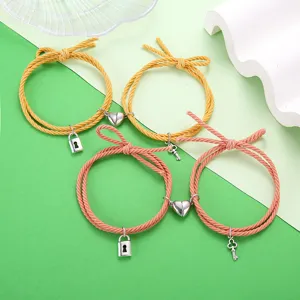 Koppel gevlochten touw armbanden met magnetisch hart slot en sleutels in geel roze.