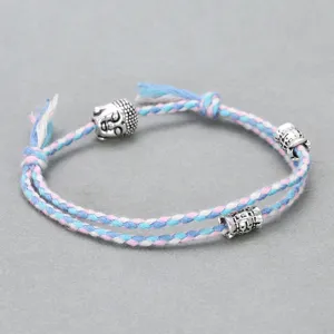 Handmade braided cotton rope bracelet featuring alloy buddha head and decorative metal cylinder charms.