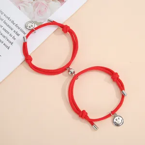 Red braided magnetic couple bracelets with metal smiley face charms for sweet daily wear.