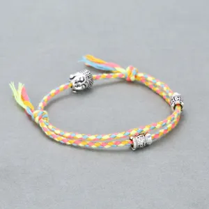 Handmade colorful cotton braided bracelet featuring a silver alloy Buddha head and engraved beads.